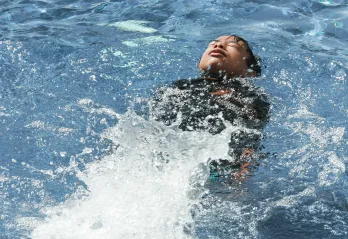 kid swimming in a pool on his back