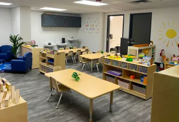 classroom with tables and chairs and shelves
