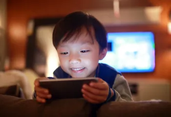 child looking at screen with TV in the background