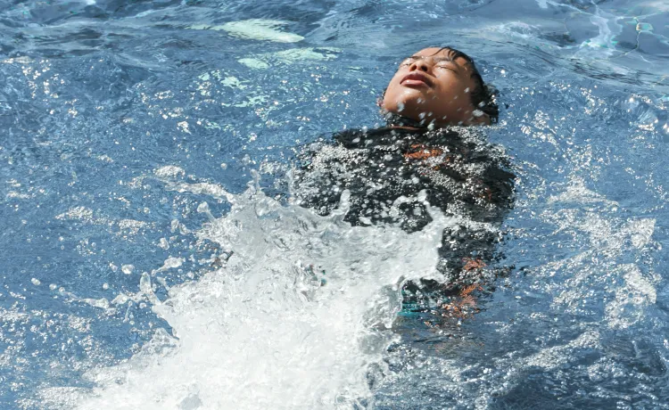 kid swimming in a pool on his back
