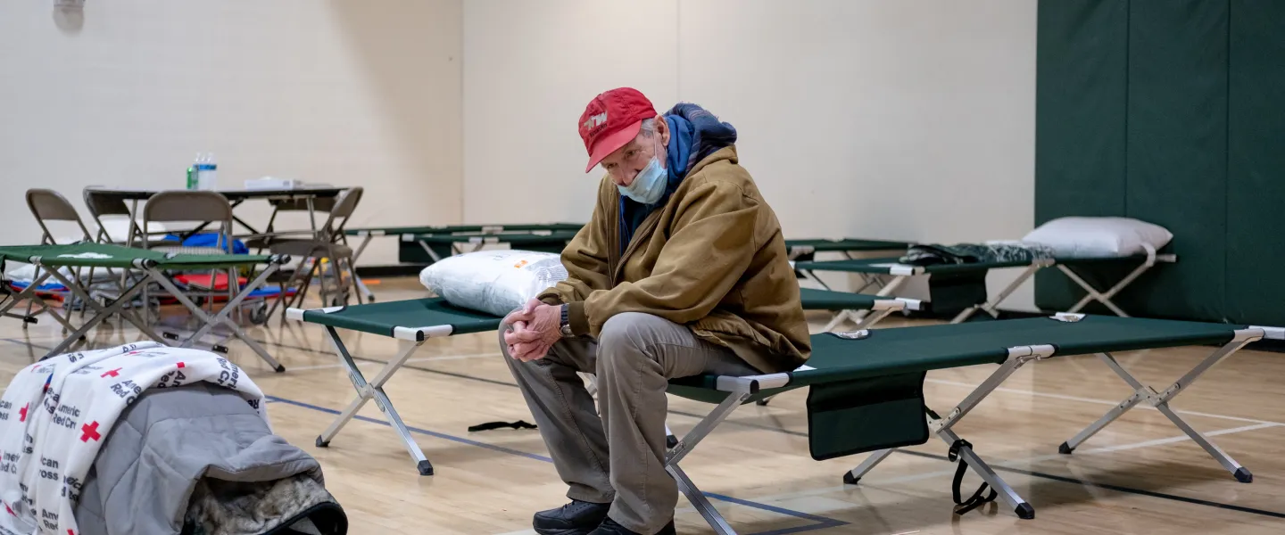 Man sitting in the gym at the Y, seeking refuge during the Marshall Fire crisis