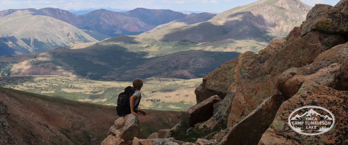 Teen on a mountaintop looking out over the Colorado landscape