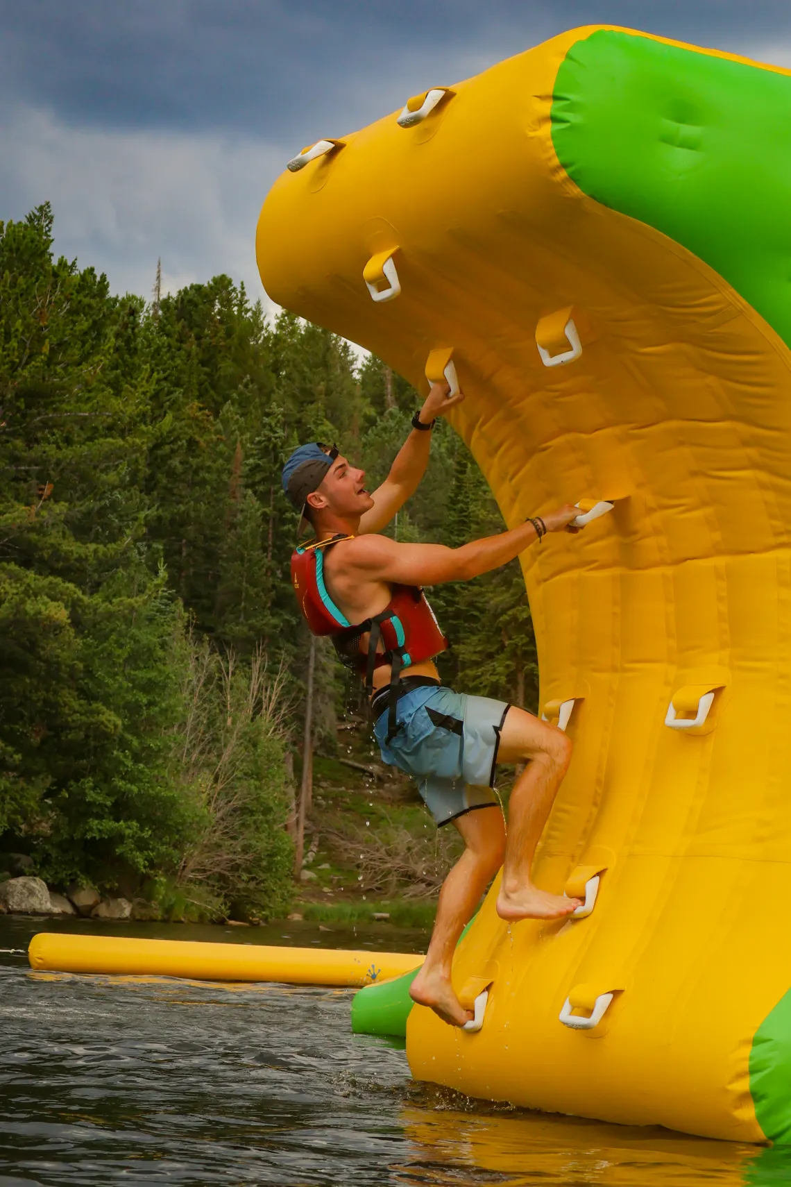 Staff member climbing up the inflatable obstacle course